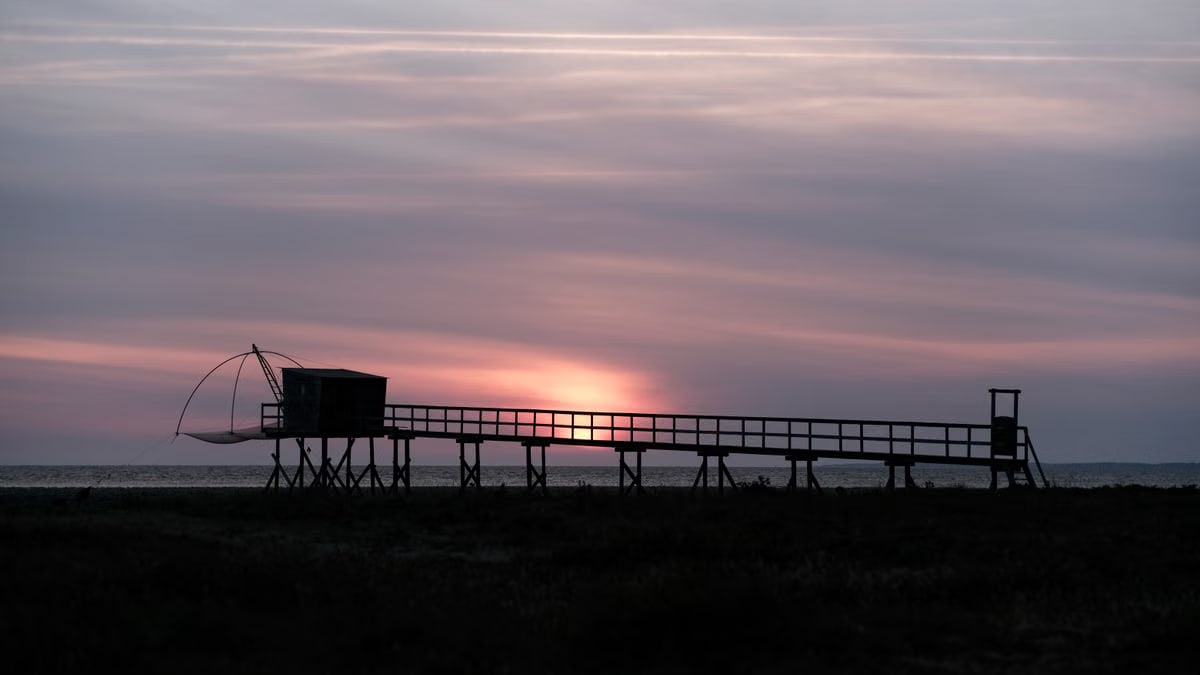 Beautiful sunset over a fishing pier in Les Moutiers-en-Retz, France.