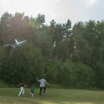 Family having fun flying a kite in a sunny park. Perfect day for outdoor bonding.